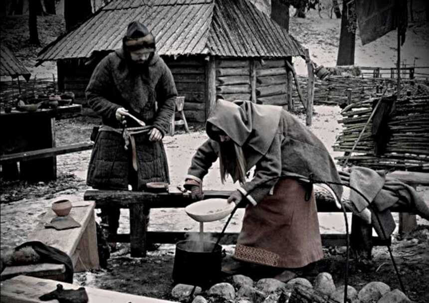 Mężczyzna i kobieta w średniowiecznych strojach przy ognisku